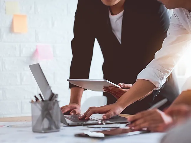 Riunione di lavoro attorno a un tavolo con appunti e computer: la fase di ascolto